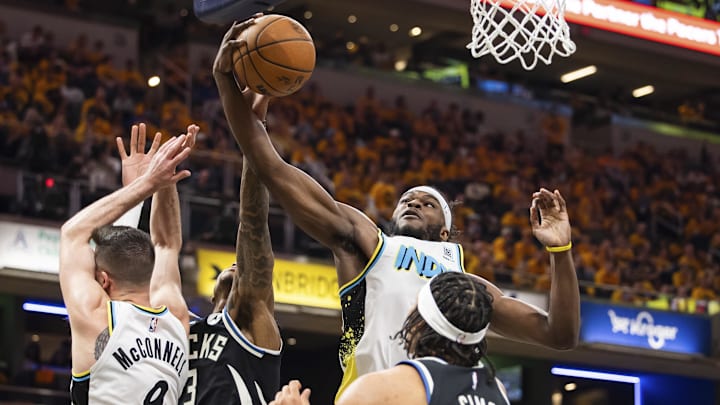 Apr 19, 2025; Indianapolis, Indiana, USA;  Indiana Pacers forward Jarace Walker (5) rebounds the ball while  Milwaukee Bucks guard Ryan Rollins (13) defends in the first half at Gainbridge Fieldhouse. Mandatory Credit: Trevor Ruszkowski-Imagn Images