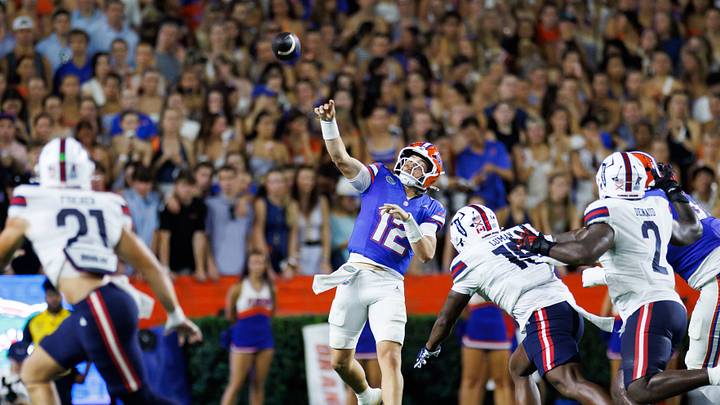 Sep 5, 2026; Gainesville, Florida, USA;  Florida Gators quarterback Aaron Philo (12) throws the ball under pressure from Florida Atlantic Owls edge Tyclean Luman (15) at Ben Hill Griffin Stadium.  Mandatory Credit: Matt Pendleton-Imagn Images