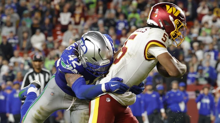 Nov 2, 2025; Landover, Maryland, USA; Seattle Seahawks linebacker Drake Thomas (42) tackles Washington Commanders quarterback Jayden Daniels (5) resulting in an injury during the second half at Northwest Stadium. Mandatory Credit: Amber Searls-Imagn Images