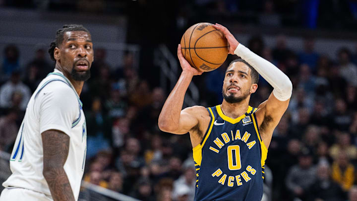 Mar 7, 2024; Indianapolis, Indiana, USA; Indiana Pacers guard Tyrese Haliburton (0) shoots the ball while Minnesota Timberwolves center Naz Reid (11) defends during the second half at Gainbridge Fieldhouse. Mandatory Credit: Trevor Ruszkowski-Imagn Images