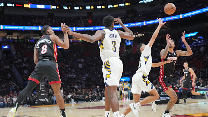 Jan 2, 2025; Miami, Florida, USA;  Miami Heat guard Josh Christopher (8) throws a pass into center Kel'el Ware (7) as Indiana Pacers guard Ben Sheppard (26) defends during the second half at Kaseya Center. Mandatory Credit: Jim Rassol-Imagn Images
