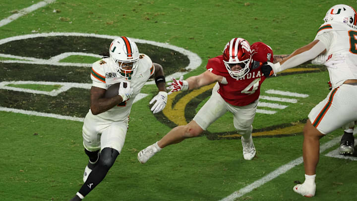 Jan 19, 2026; Miami Gardens, FL, USA; Miami Hurricanes running back Mark Fletcher Jr. (4) carries the ball defended by Indiana Hoosiers linebacker Aiden Fisher (4) in the third quarter during the College Football Playoff National Championship game at Hard Rock Stadium. Mandatory Credit: Kim Klement Neitzel-Imagn Images