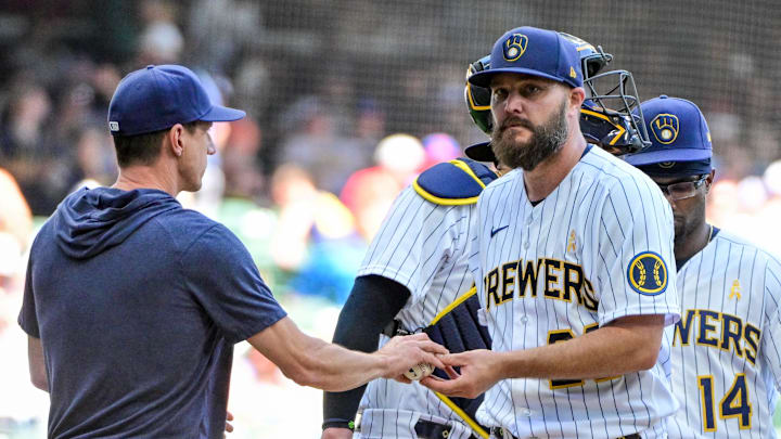Milwaukee Brewers pitcher Wade Miley (20) hands the ball to manager Craig Counsell during a pitching change in the seventh inning against the Philadelphia Phillies at American Family Field in 2023.