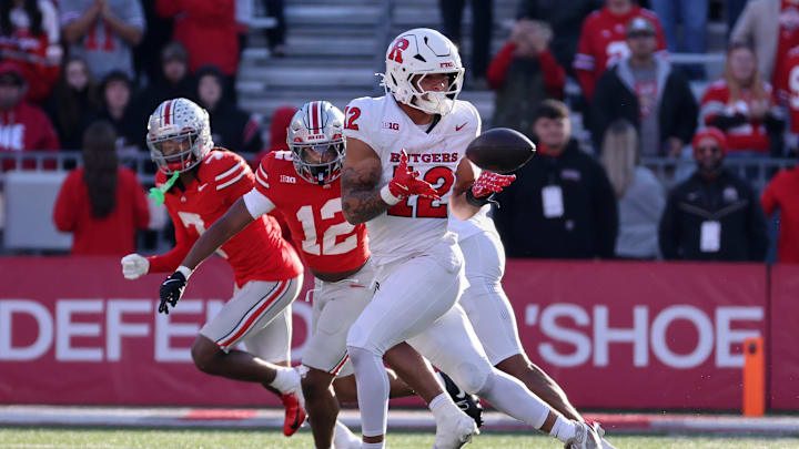 Nov 22, 2025; Columbus, Ohio, USA; Rutgers Scarlet Knights tight end Kenny Fletcher Jr. (12) catches a pass against Ohio State Buckeyes cornerbacks Bryce West (12) and Jermaine Mathews Jr. (7) during the fourth quarter at Ohio Stadium. Mandatory Credit: Joseph Maiorana-Imagn Images