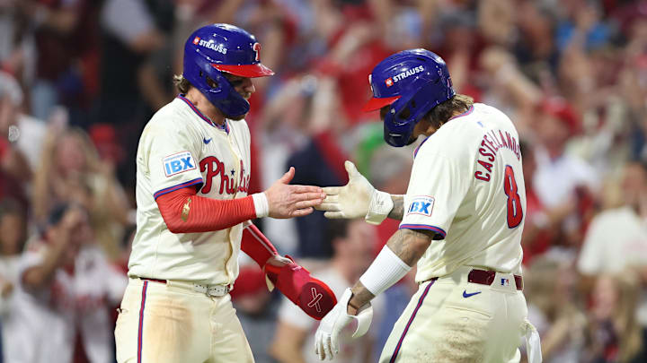 Oct 6, 2024; Philadelphia, Pennsylvania, USA; Philadelphia Phillies outfielder Nick Castellanos (8) and first base Bryce Harper (3) celebrate after scoring a run in the eighth inning against the New York Mets during game two of the NLDS for the 2024 MLB Playoffs at Citizens Bank Park. Mandatory Credit: Bill Streicher-Imagn Images