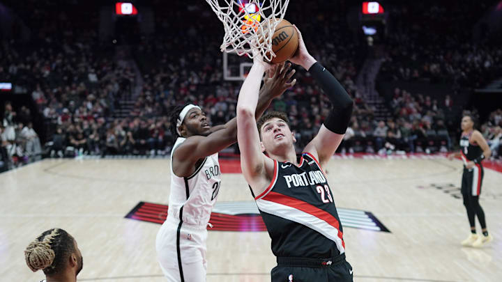 Jan 14, 2025; Portland, Oregon, USA; Portland Trail Blazers center Donovan Clingan (23) shoots the ball against Brooklyn Nets center Day'Ron Sharpe (20) during the first half at Moda Center. Mandatory Credit: Soobum Im-Imagn Images