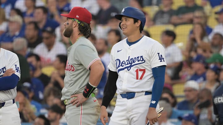 Los Angeles, California, USA;  Los Angeles Dodgers designated hitter Shohei Ohtani (17) laughs with Philadelphia Phillies first baseman Bryce Harper (3) as they wait for a replay in the first inning at Dodger Stadium.