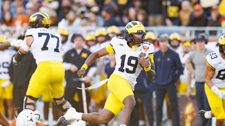Dec 31, 2025; Orlando, FL, USA; Michigan Wolverines quarterback Bryce Underwood (19) runs with the ball after breaking a tackle against the Texas Longhorns during the second half at Camping World Stadium. Mandatory Credit: Matt Pendleton-Imagn Images