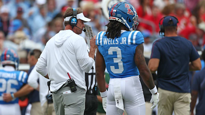 Sep 28, 2024; Oxford, Mississippi, USA; Mississippi Rebels head coach Lane Kiffin talks with wide receiver Antwane Wells Jr. (3) during a time out during the first half against the Kentucky Wildcats at Vaught-Hemingway Stadium. Mandatory Credit: Petre Thomas-Imagn Images