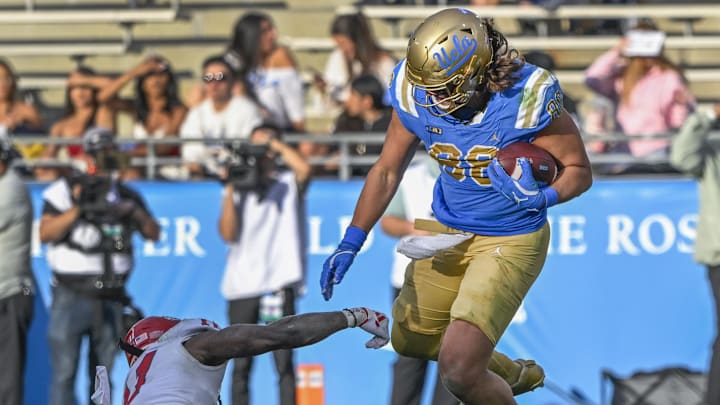 Nov 30, 2024; Pasadena, California, USA; UCLA Bruins tight end Moliki Matavao (88) breaks a tackle by Fresno State Bulldogs defensive back Jayden Davis (11) during the fourth quarter at Rose Bowl. Mandatory Credit: Robert Hanashiro-Imagn Images