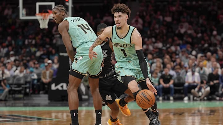 Feb 7, 2025; Charlotte, North Carolina, USA; Charlotte Hornets guard LaMelo Ball (1) dribbles around a pick by forward Moussa Diabate (14) against the San Antonio Spurs during the first quarter at Spectrum Center. Mandatory Credit: Jim Dedmon-Imagn Images