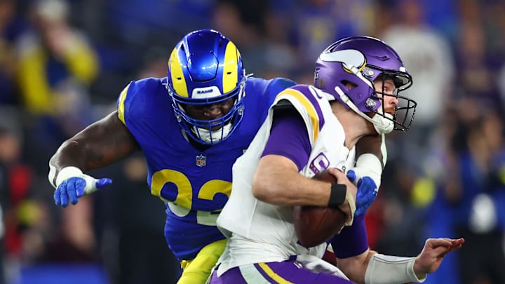 Jan 13, 2025; Glendale, AZ, USA; Minnesota Vikings quarterback Sam Darnold (14) is sacked by Los Angeles Rams defensive tackle Neville Gallimore (92) during the second half in an NFC wild card game at State Farm Stadium. Mandatory Credit: Mark J. Rebilas-Imagn Images