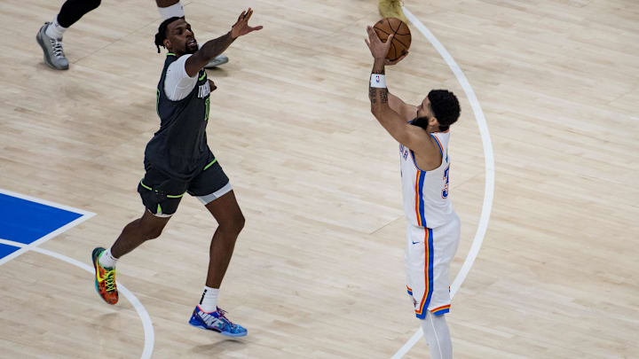 May 20, 2025; Oklahoma City, Oklahoma, USA; Oklahoma City Thunder forward Kenrich Williams (right) shoots against Minnesota Timberwolves center Naz Reid (left) in the third quarter during Game 1 of the Western Conference Finals at Paycom Center. Mandatory Credit: Brett Rojo-Imagn Images