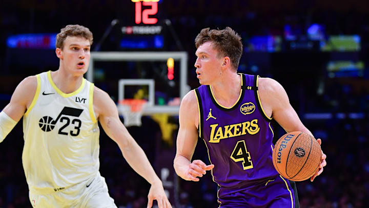 Nov 19, 2024; Los Angeles, California, USA; Los Angeles Lakers guard Dalton Knecht (4) moves to the basket agianst Utah Jazz forward Lauri Markkanen (23) during the first half at Crypto.com Arena. Mandatory Credit: Gary A. Vasquez-Imagn Images