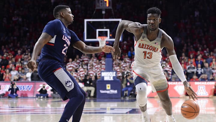 Dec 21, 2017; Tucson, AZ, USA; Arizona Wildcats forward Deandre Ayton (13) dribbles the ball as Connecticut Huskies forward Eric Cobb (23) defends during the second half at McKale Center. Mandatory Credit: Casey Sapio-Imagn Images