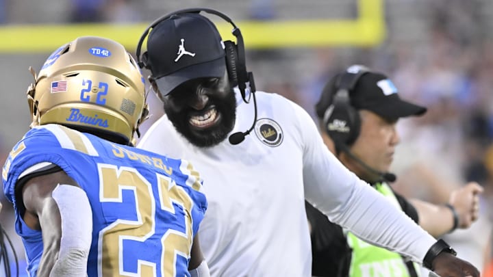Oct 12, 2024; Pasadena, California, USA; UCLA Bruins running back Keegan Jones (22) celebrates with head coach DeShaun Foster after scoring a touchdown against the Minnesota Golden Gophers during the first quarter at Rose Bowl. Mandatory Credit: Robert Hanashiro-Imagn Images