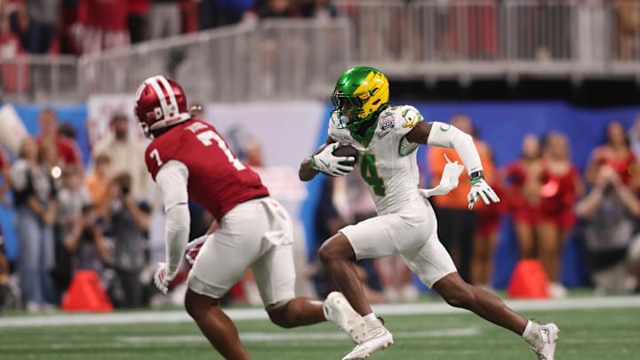 Jan 9, 2026; Atlanta, GA, USA; Oregon Ducks wide receiver Malik Benson (4) runs the ball against Indiana Hoosiers defensive back Louis Moore (7) during the first quarter of the 2025 Peach Bowl and semifinal game of the College Football Playoff at Mercedes-Benz Stadium. Mandatory Credit: Brett Davis-Imagn Images