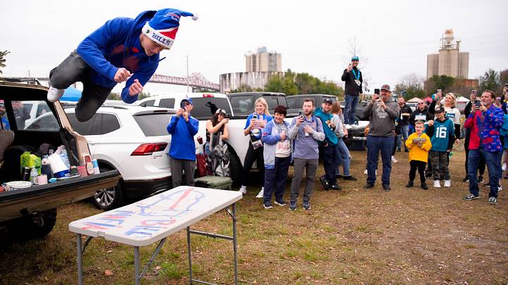 Fans chanted “Lets go Buffalo!’ as Bills Mafia member Seth McDonald, 14, leaps to a folding table as fans watch before an NFL football AFC Wild Card playoff matchup, Sunday, Jan. 11, 2026, in Jacksonville, Fla. [Doug Engle/Florida Times-Union]