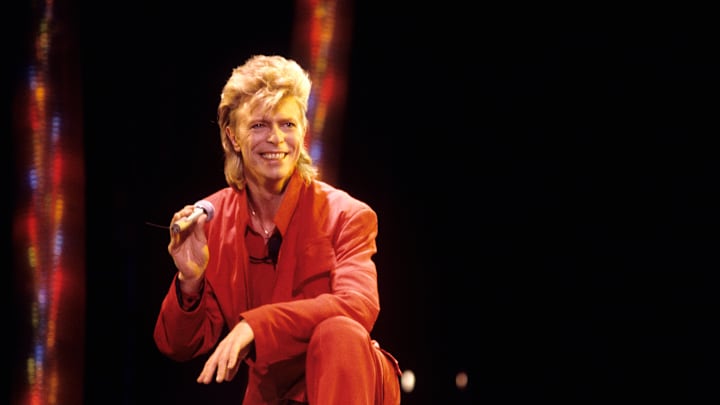David Bowie onstage in a red suit