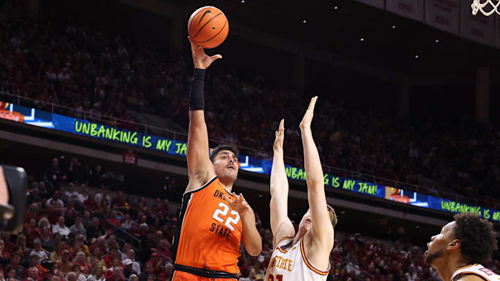 Jan 10, 2026; Ames, Iowa, USA; Oklahoma State Cowboys center Parsa Fallah (22) scores over Iowa State Cyclones forward Dominykas Pleta (21) during the second half at James H. Hilton Coliseum. Mandatory Credit: Reese Strickland-Imagn Images