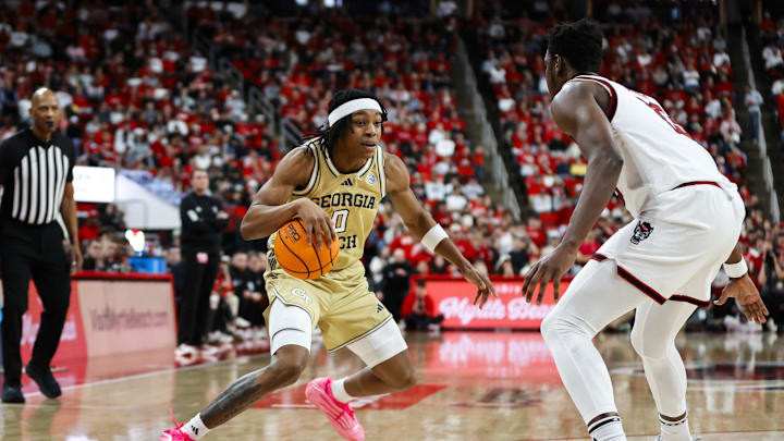 Jan 17, 2026; Raleigh, North Carolina, USA; Georgia Tech Yellow Jackets guard Akai Fleming (0) dribbles with the ball guarded by NC State Wolfpack forward Jerry Deng (15) during the second half of the game at Lenovo Center. Mandatory Credit: Jaylynn Nash-Imagn Images