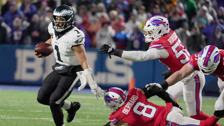 Philadelphia Eagles quarterback Jalen Hurts avoids Buffalo Bills linebacker Terrel Bernard, defensive end Greg Rousseau and defensive end Joey Bosa, who were all trying to sack him during first half action against the Philadelphia Eagles at Highmark Stadium in Orchard Park on Dec. 28, 2025.