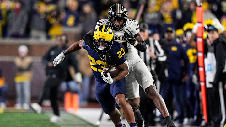 Michigan running back Jordan Marshall (23) runs against Purdue defensive back Tahj Ra-El (21) during the second half at Michigan Stadium in Ann Arbor on Saturday, November 1, 2025.