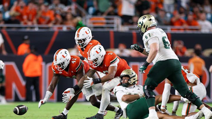 Sep 13, 2025; Miami Gardens, Florida, USA; Miami Hurricanes linebacker Chase Smith (41) linebacker Mohamed Toure (1) and defensive lineman Akheem Mesidor (3) scramble for a loose ball against the South Florida Bulls in the third quarter at Hard Rock Stadium. Mandatory Credit: Nathan Ray Seebeck-Imagn Images Sep 13, 2025; Miami Gardens, Florida, USA; Miami Hurricanes linebacker Chase Smith (41) linebacker Mohamed Toure (1) and defensive lineman Akheem Mesidor (3) scramble for a loose ball against the South Florida Bulls in the third quarter at Hard Rock Stadium. Mandatory Credit: Nathan Ray Seebeck-Imagn Images