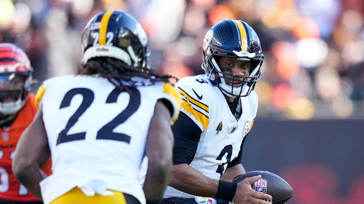 Pittsburgh Steelers quarterback Russell Wilson looks to pass the ball off to running back Najee Harris.