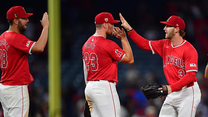 August 16, 2024; Anaheim, California, USA; Los Angeles Angels first baseman Nolan Schanuel (18) second base Brandon Drury (23) and left fielder Taylor Ward (3) celebrate the victory against the Atlanta Braves at Angel Stadium. Mandatory Credit: Gary A. Vasquez-Imagn Images