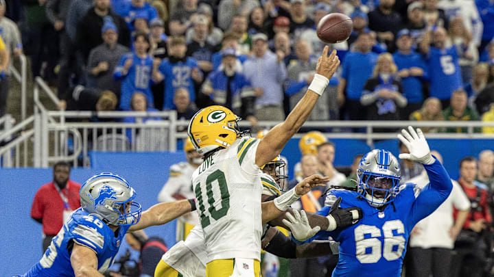 Green Bay Packers quarterback Jordan Love completes a long pass while being pressured by Jack Campbell (46) and Myles Adams.
