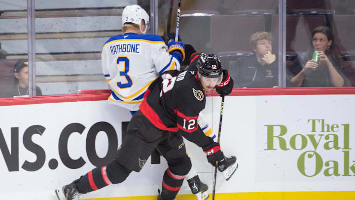 Sep 26, 2024; Ottawa, Ontario, CAN; Buffalo Sabres defenseman Jack Rathbone (3) is checked by Ottawa Senators center Shane Pinto (12) in the third period at the Canadian Tire Centre. Mandatory Credit: Marc DesRosiers-Imagn Images Sep 26, 2024; Ottawa, Ontario, CAN; Buffalo Sabres defenseman Jack Rathbone (3) is checked by Ottawa Senators center Shane Pinto (12) in the third period at the Canadian Tire Centre. Mandatory Credit: Marc DesRosiers-Imagn Images