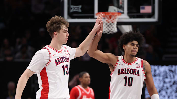 Mar 14, 2026; Kansas City, MO, USA; Arizona Wildcats center Motiejus Krivas (13) and forward Koa Peat (10) high-five during the second half against the Houston Cougars during the men's Big 12 Conference Tournament Championship at T-Mobile Center. Mandatory Credit: William Purnell-Imagn Images