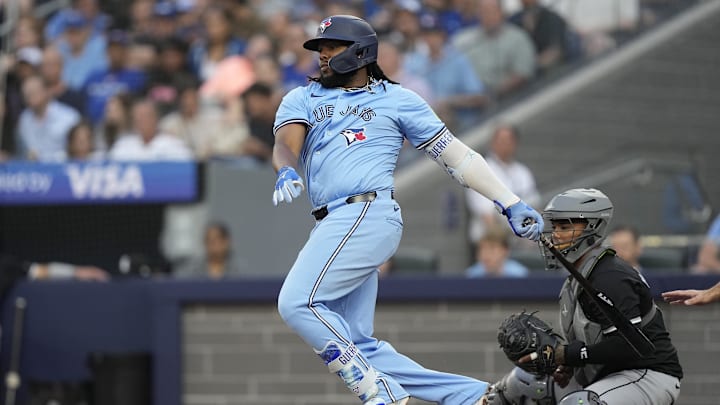 May 22, 2024; Toronto, Ontario, CAN; Toronto Blue Jays first baseman Vladimir Guerrero Jr. (27) hits a RBI single against the Chicago White Sox during the second inning at Rogers Centre. Mandatory Credit: John E. Sokolowski-USA TODAY Sports
