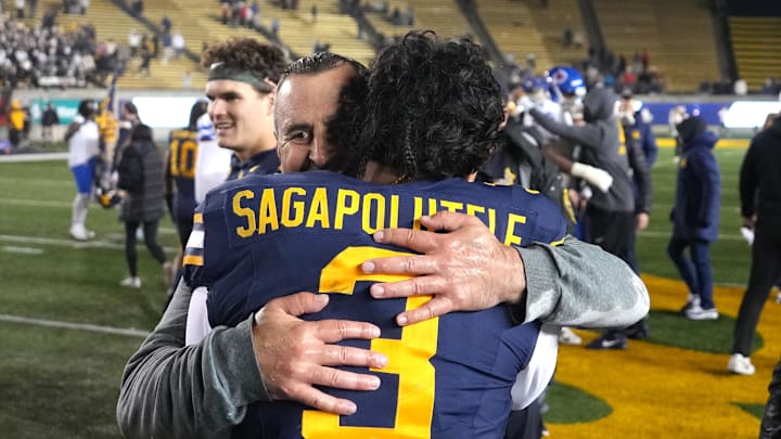 Cal interim head coach Nick Rolovich  hugs quarterback Jaron-Keawe Sagapolutele after defeating SMU. Both have connections to Hawaii