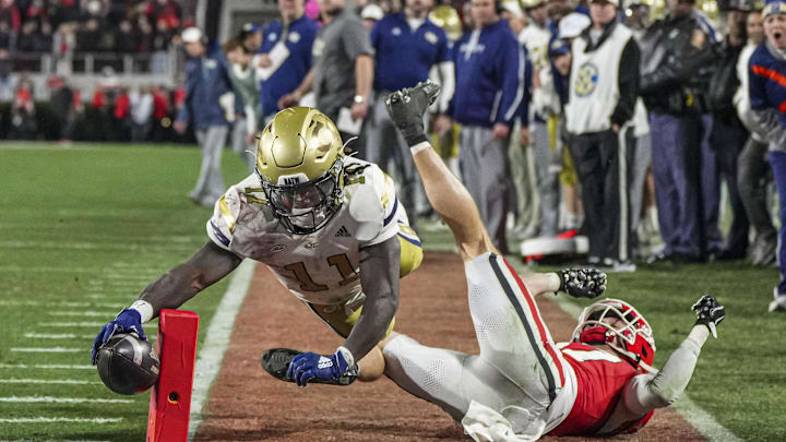 Nov 29, 2024; Athens, Georgia, USA; Georgia Tech Yellow Jackets running back Jamal Haynes (11) scores a touchdown past Georgia Bulldogs defensive back Dan Jackson (17) during the first half at Sanford Stadium. Mandatory Credit: Dale Zanine-Imagn Images Nov 29, 2024; Athens, Georgia, USA; Georgia Tech Yellow Jackets running back Jamal Haynes (11) scores a touchdown past Georgia Bulldogs defensive back Dan Jackson (17) during the first half at Sanford Stadium. Mandatory Credit: Dale Zanine-Imagn Images