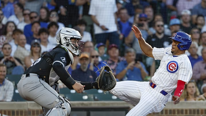 Jun 5, 2024; Chicago, Illinois, USA; Chicago Cubs third baseman Christopher Morel (5) slides to score as Chicago White Sox catcher Martín Maldonado (15) waits for the ball during the second inning at Wrigley Field. Mandatory Credit: Kamil Krzaczynski-Imagn Images
