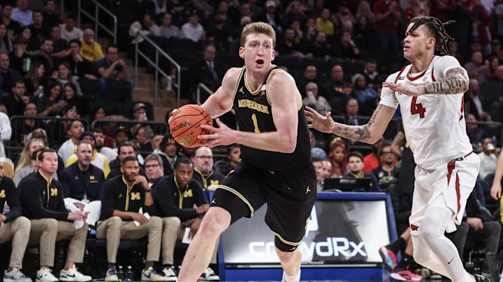 Dec 10, 2024; New York, New York, USA;  Michigan Wolverines center Danny Wolf (1) drives past Arkansas Razorbacks forward Trevon Brazile (4) in the second half at Madison Square Garden. Mandatory Credit: Wendell Cruz-Imagn Images