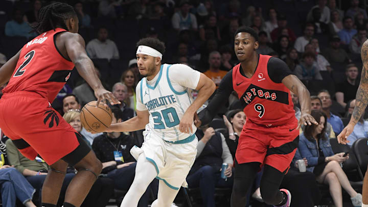 Oct 30, 2024; Charlotte, North Carolina, USA; Charlotte Hornets guard Seth Curry (30) drives past Toronto Raptors forward Jonathan Mogbo (2) during the first half at the Spectrum Center. Mandatory Credit: Sam Sharpe-Imagn Images