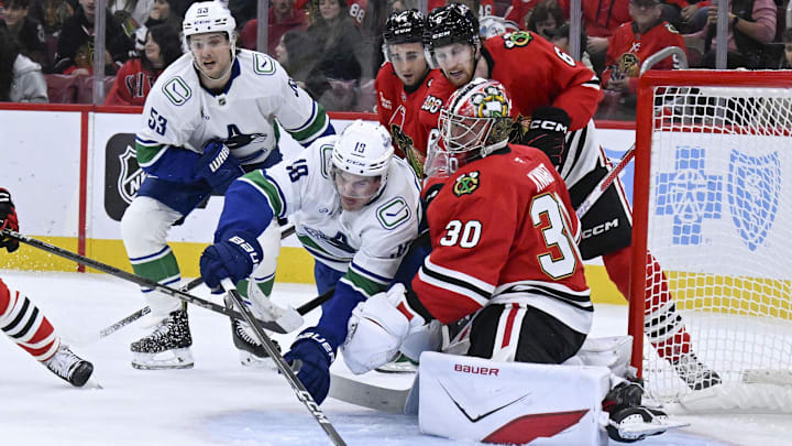 Oct 17, 2025; Chicago, Illinois, USA;  Vancouver Canucks left wing Drew O'Connor (18) shoots against Chicago Blackhawks goaltender Spencer Knight (30) during the first period at the United Center. Mandatory Credit: Matt Marton-Imagn Images