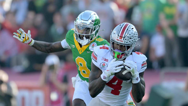 Jan 1, 2025; Pasadena, CA, USA; Ohio State Buckeyes wide receiver Jeremiah Smith (4) makes a catch against Oregon Ducks defensive back Dontae Manning (8) in the first quarter in the 2025 Rose Bowl college football quarterfinal game at Rose Bowl Stadium. Mandatory Credit: Jayne Kamin-Oncea-Imagn Images