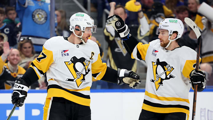 Mar 27, 2025; Buffalo, New York, USA;  Pittsburgh Penguins center Sidney Crosby (87) celebrates his goal with defenseman Matt Grzelcyk (24) during the first period against the Buffalo Sabres at KeyBank Center. Mandatory Credit: Timothy T. Ludwig-Imagn Images