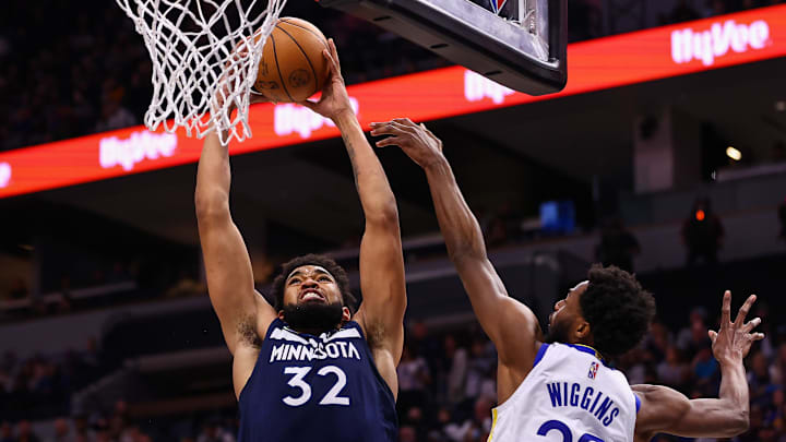 Mar 1, 2022; Minneapolis, Minnesota, USA; Minnesota Timberwolves center Karl-Anthony Towns (32) drives to the basket as Golden State Warriors forward Andrew Wiggins (22) guards him during the third quarter at Target Center. Mandatory Credit: Harrison Barden-Imagn Images