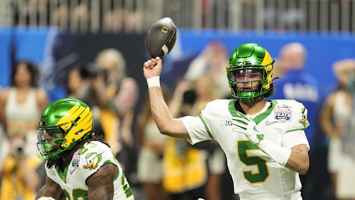 Jan 9, 2026; Atlanta, GA, USA; Oregon Ducks quarterback Dante Moore (5) fumbles against the Indiana Hoosiers during the first half of the 2025 Peach Bowl and semifinal game of the College Football Playoff at Mercedes-Benz Stadium. Mandatory Credit: Dale Zanine-Imagn Images