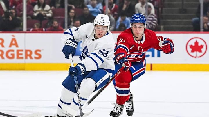Sep 30, 2023; Montreal, Quebec, CAN; Toronto Maple Leafs right wing Easton Cowan (53) plays the puck against Montreal Canadiens left wing Juraj Slafkovsky (20) during the first period at Bell Centre. Mandatory Credit: David Kirouac-USA TODAY Sports
