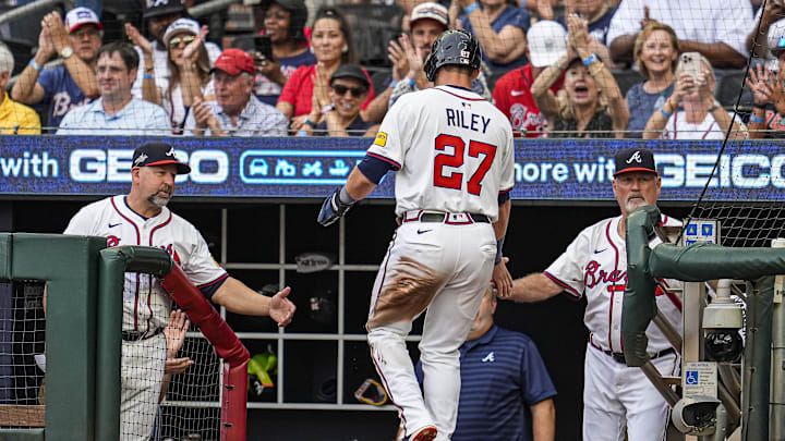 Jun 18, 2025; Cumberland, Georgia, USA; Atlanta Braves third baseman Austin Riley (27) is greeted by bench coach/infield coach Walt Weiss (4) and manager Brian Snitker (43) after scoring a run against the New York Mets during the first inning at Truist Park. Mandatory Credit: Dale Zanine-Imagn Images