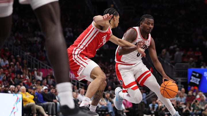 Mar 14, 2026; Kansas City, MO, USA; Arizona Wildcats guard Jaden Bradley (0) drives to the hoop past Houston Cougars guard Milos Uzan (7) during the first half during the men's Big 12 Conference Tournament Championship at T-Mobile Center. Mandatory Credit: William Purnell-Imagn Images Mar 14, 2026; Kansas City, MO, USA; Arizona Wildcats guard Jaden Bradley (0) drives to the hoop past Houston Cougars guard Milos Uzan (7) during the first half during the men's Big 12 Conference Tournament Championship at T-Mobile Center. Mandatory Credit: William Purnell-Imagn Images