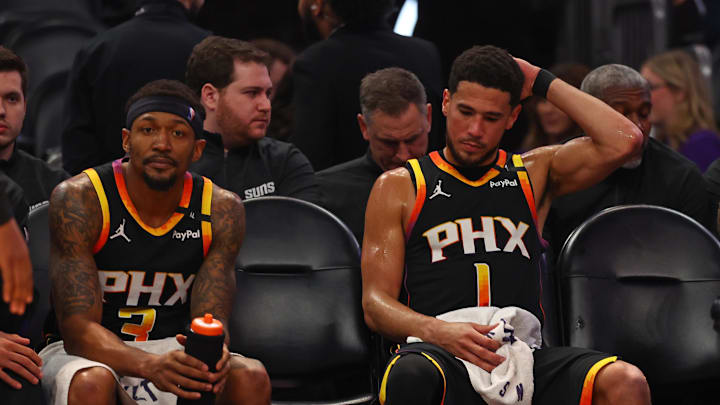 Apr 9, 2025; Phoenix, Arizona, USA; Phoenix Suns guard Bradley Beal (3) and guard Devin Booker (1) react on the bench against the Oklahoma City Thunder during the second half at Footprint Center. Mandatory Credit: Mark J. Rebilas-Imagn Images