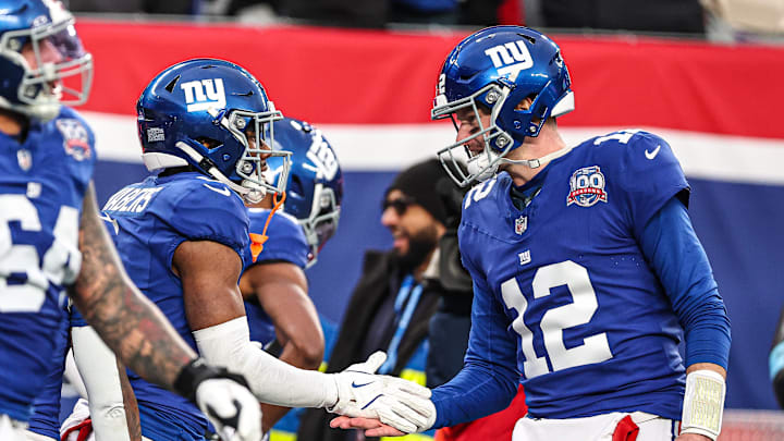Dec 15, 2024; East Rutherford, New Jersey, USA; New York Giants wide receiver Malik Nabers (1) celebrates his touchdown reception from quarterback Tim Boyle (12) during the second half against the Baltimore Ravens at MetLife Stadium. Mandatory Credit: Vincent Carchietta-Imagn Images