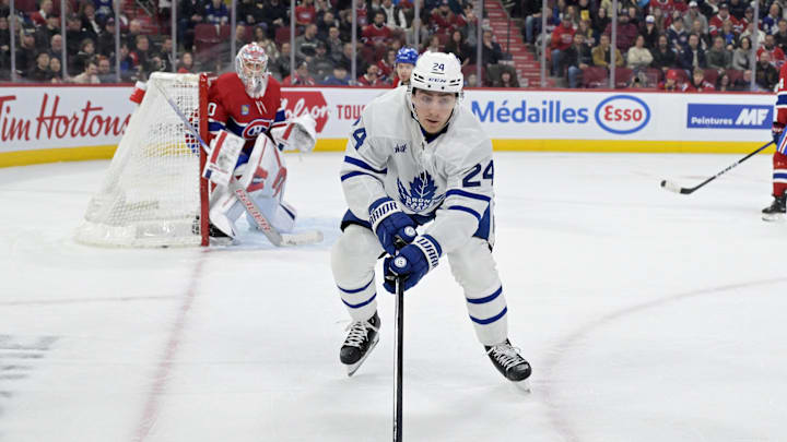 Apr 6, 2024; Montreal, Quebec, CAN; Toronto Maple Leafs forward Connor Dewar (24) plays the puck next to Montreal Canadiens goalie Cayden Primeau (30) during the third period at the Bell Centre. Mandatory Credit: Eric Bolte-USA TODAY Sports